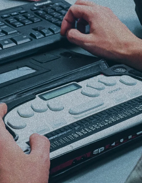 Hombre ciego usando un lector de pantalla en braille