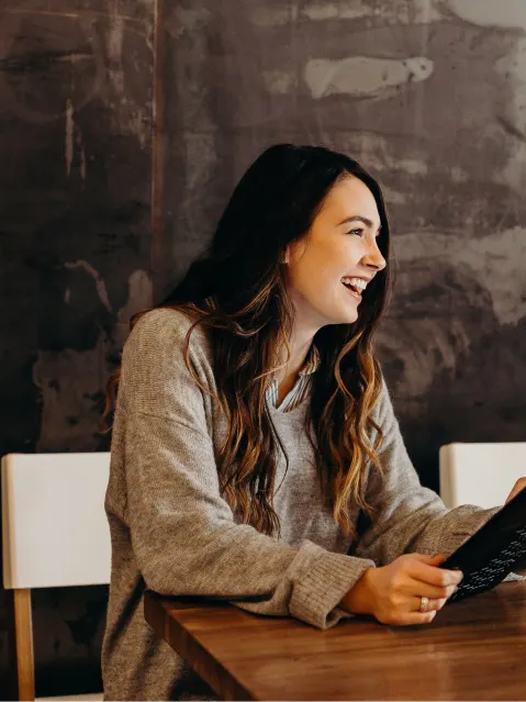 Young girl smiling in profile with tablet in hands