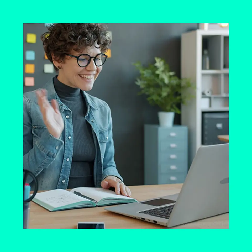 Young person smiling and looking at a laptop